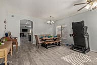 dining room featuring ceiling fan with notable chandelier and hardwood / wood-style flooring