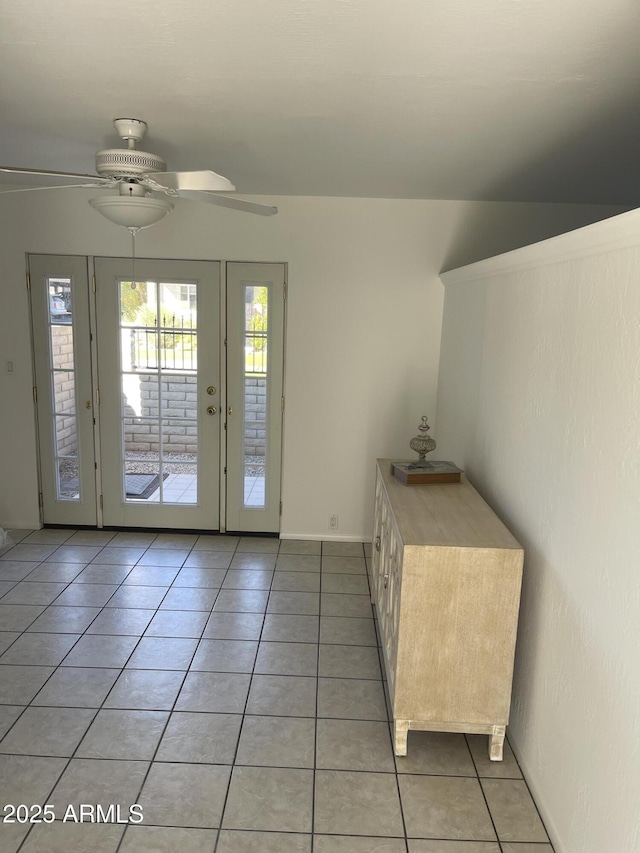 doorway featuring ceiling fan and light tile patterned flooring