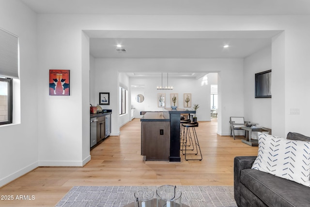 living room featuring a notable chandelier and light wood-type flooring