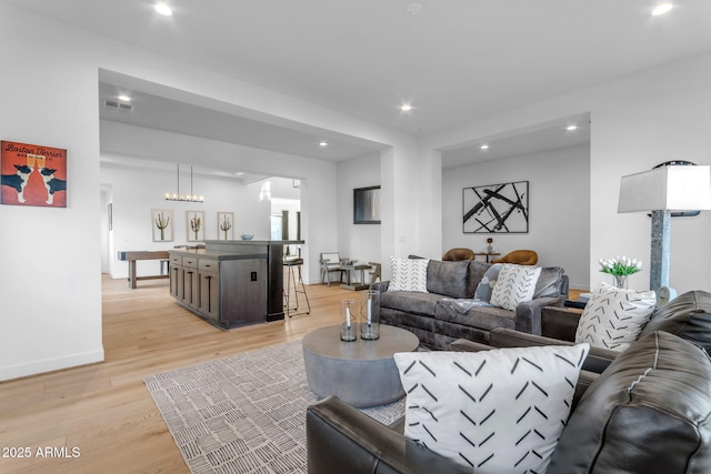 living room featuring light hardwood / wood-style floors and a notable chandelier