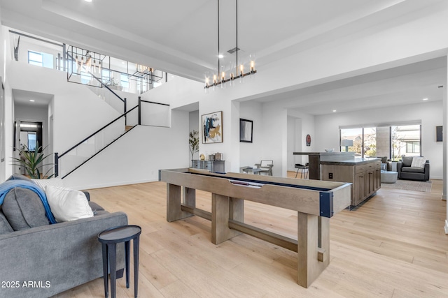 recreation room with a chandelier and light hardwood / wood-style floors