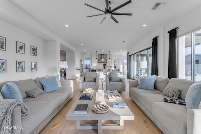 living room featuring ceiling fan and light hardwood / wood-style floors