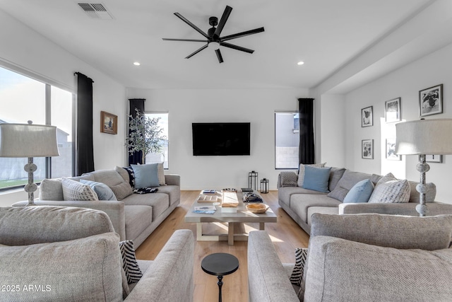 living room with light hardwood / wood-style flooring and ceiling fan