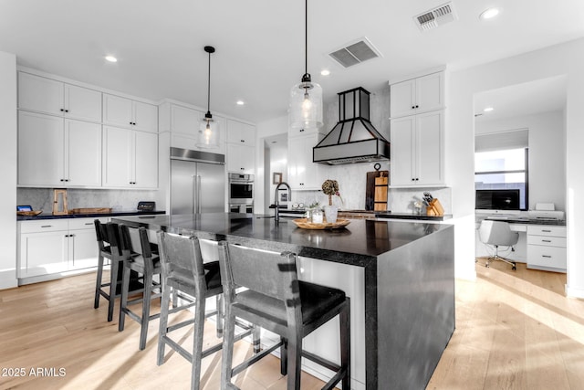 kitchen featuring tasteful backsplash, stainless steel appliances, sink, a center island with sink, and a breakfast bar area