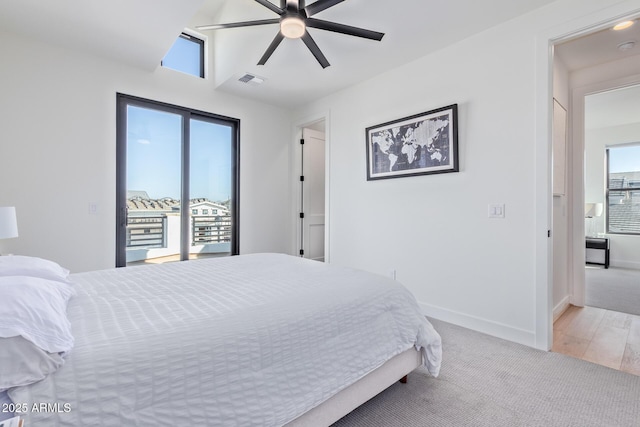 bedroom with access to exterior, light hardwood / wood-style floors, vaulted ceiling, and ceiling fan