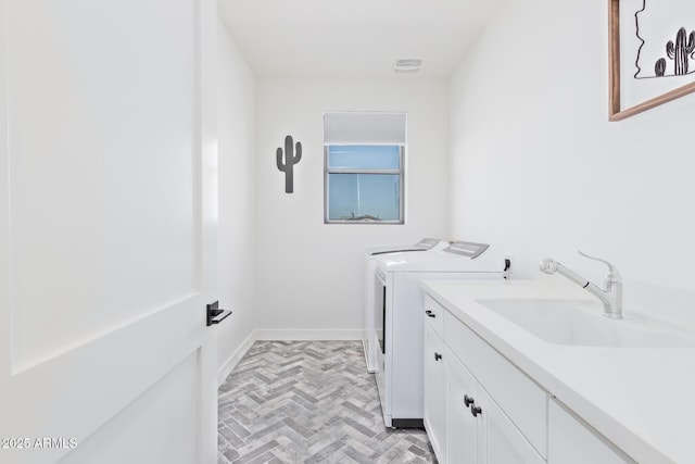 laundry room featuring cabinets, washer and clothes dryer, and sink