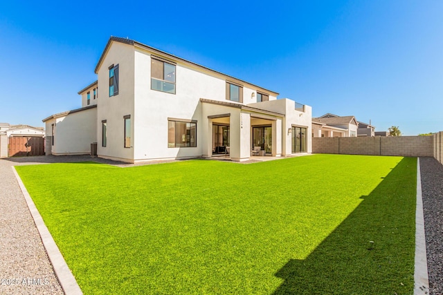 rear view of property featuring a yard and a patio