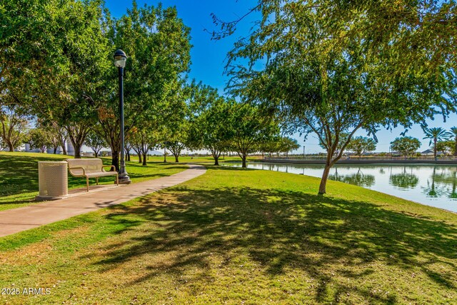 view of home's community with a water view and a yard