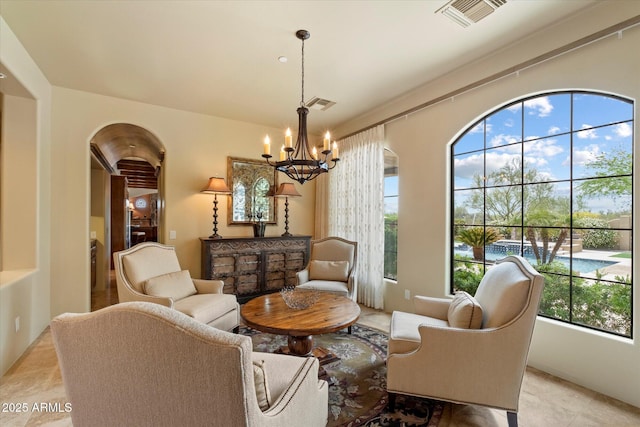 sitting room with arched walkways, a notable chandelier, and visible vents