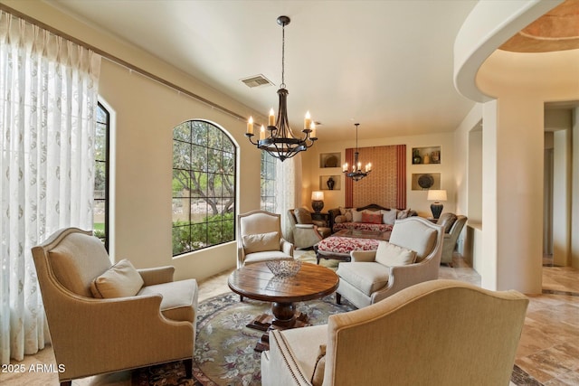 sitting room with an inviting chandelier, built in features, plenty of natural light, and visible vents