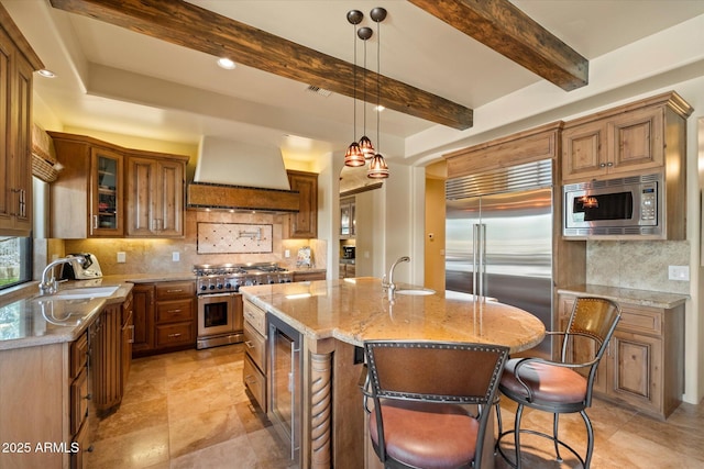 kitchen featuring built in appliances, wine cooler, tasteful backsplash, custom range hood, and a sink