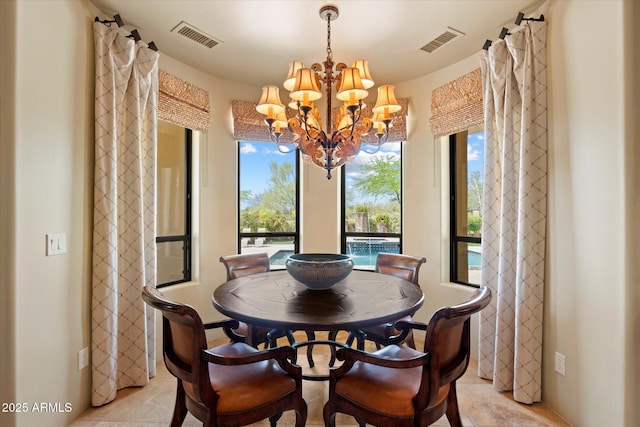 dining space with visible vents, a wealth of natural light, and an inviting chandelier