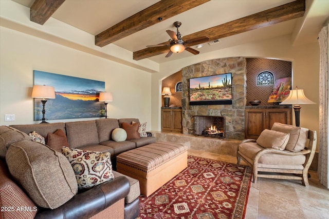 living area featuring ceiling fan, a fireplace, arched walkways, beamed ceiling, and visible vents