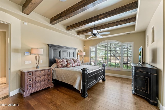 bedroom featuring baseboards, dark wood finished floors, ceiling fan, and beam ceiling