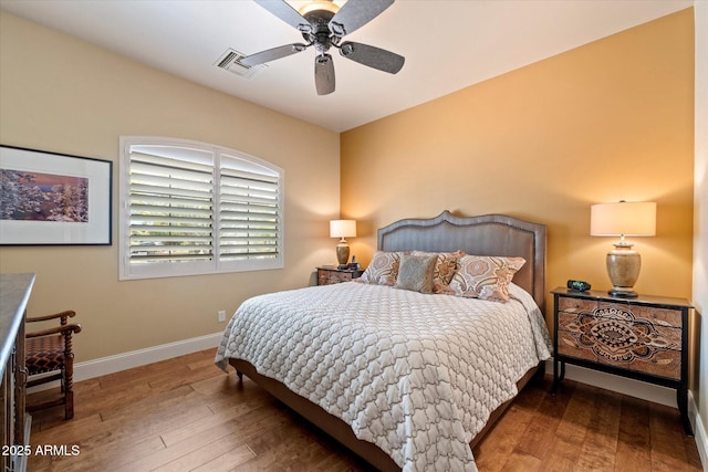 bedroom featuring baseboards, ceiling fan, visible vents, and hardwood / wood-style floors