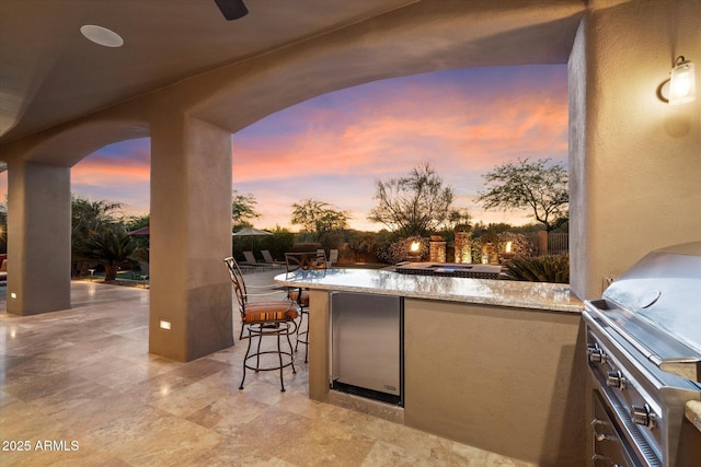 view of patio featuring outdoor wet bar, exterior kitchen, and area for grilling