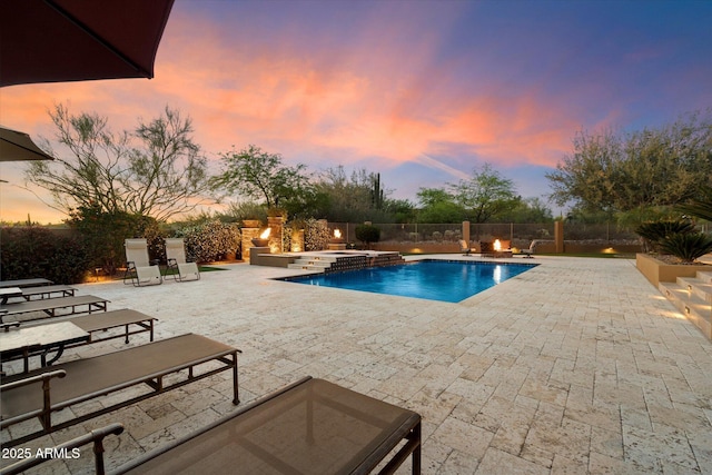 pool at dusk featuring a patio, a fenced backyard, an in ground hot tub, and a fenced in pool