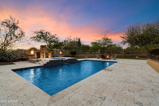 view of swimming pool featuring a patio area, fence, and a pool with connected hot tub