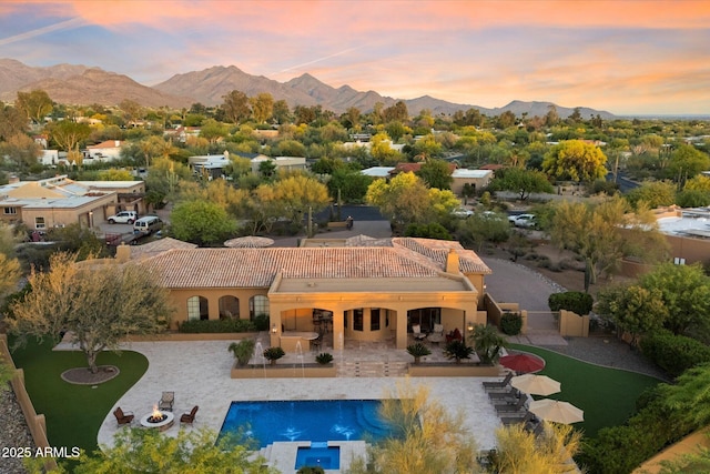 exterior space with central AC, a mountain view, a patio area, curved driveway, and a tiled roof