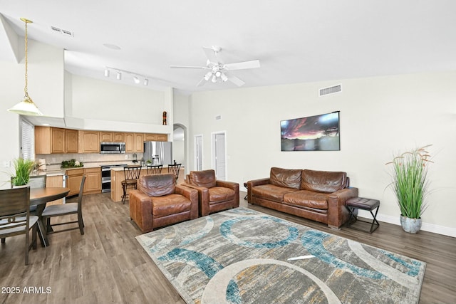 living room with visible vents, baseboards, and light wood-style floors