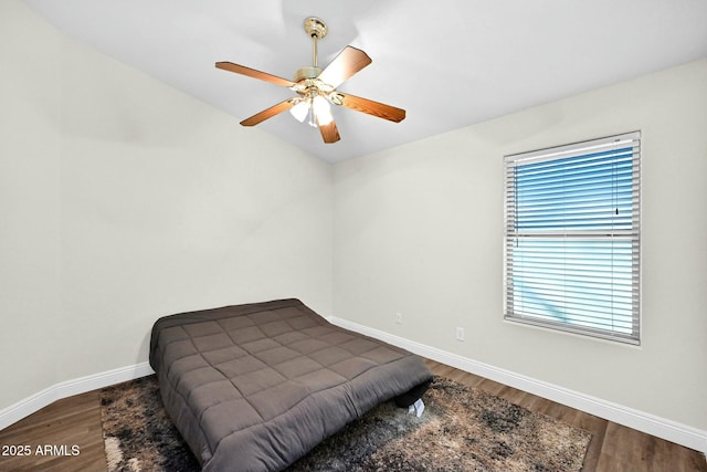 bedroom with a ceiling fan, baseboards, and dark wood-style flooring