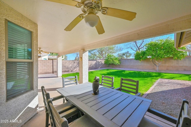 view of patio with outdoor dining area, a fenced backyard, and a ceiling fan