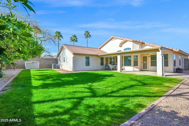 back of property featuring a yard, a patio, fence private yard, and stucco siding