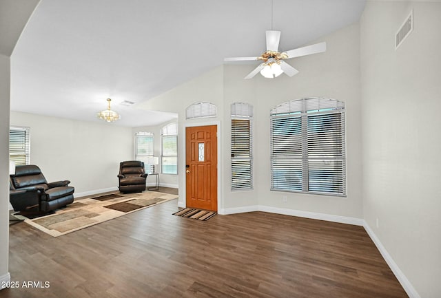 foyer with visible vents, dark wood-type flooring, baseboards, ceiling fan with notable chandelier, and high vaulted ceiling