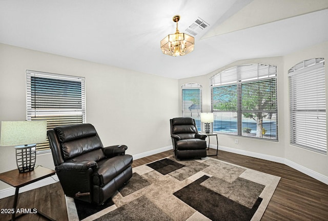 living area with a chandelier, baseboards, visible vents, and wood finished floors