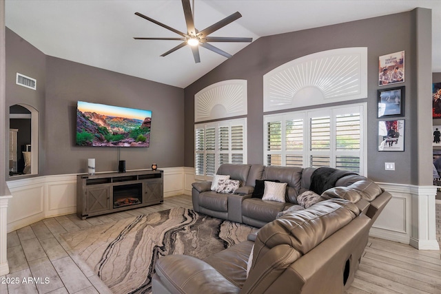 7925 E Osage Ave, Mesa, AZ 85212 - living room with a decorative wall, light wood-style flooring, lofted ceiling, a ceiling fan, and wainscoting