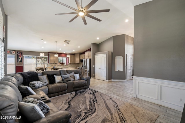 7925 E Osage Ave, Mesa, AZ 85212 - living room with ceiling fan, vaulted ceiling, light wood-style floors, a wainscoted wall, and a decorative wall