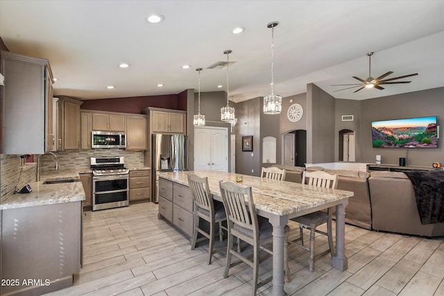 7925 E Osage Ave, Mesa, AZ 85212 - kitchen with stainless steel appliances, vaulted ceiling, a sink, light wood-type flooring, and arched walkways