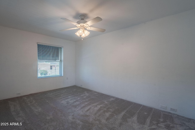 empty room featuring dark colored carpet and ceiling fan