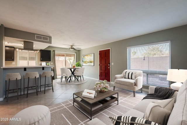 tiled living room with ceiling fan