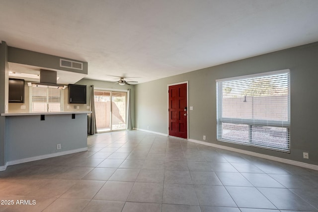 unfurnished living room featuring ceiling fan and light tile patterned floors