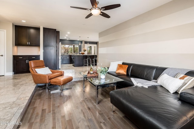 living area featuring ceiling fan, light wood finished floors, and recessed lighting