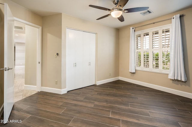 unfurnished bedroom featuring wood tiled floor, a closet, visible vents, and baseboards