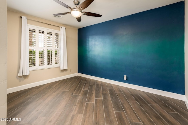 spare room with a ceiling fan, wood finish floors, and baseboards