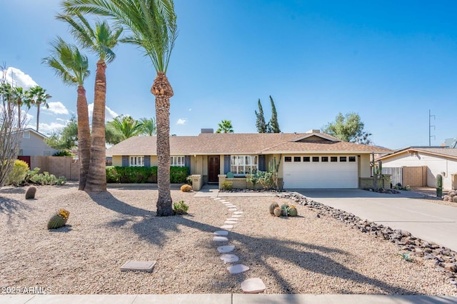 ranch-style home with fence, driveway, and an attached garage