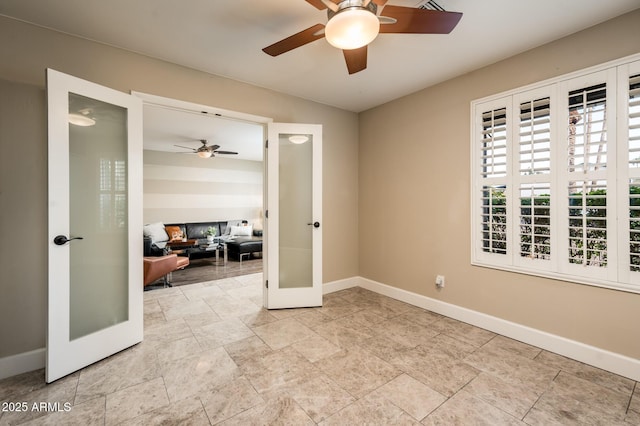 unfurnished room featuring ceiling fan, baseboards, and french doors