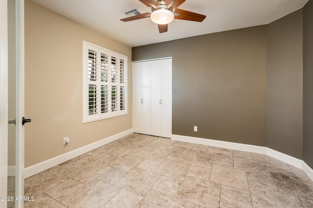 unfurnished bedroom with a closet, visible vents, ceiling fan, and baseboards