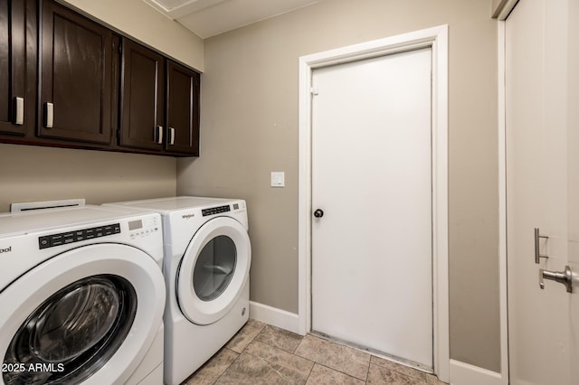 clothes washing area with washing machine and dryer, cabinet space, and baseboards