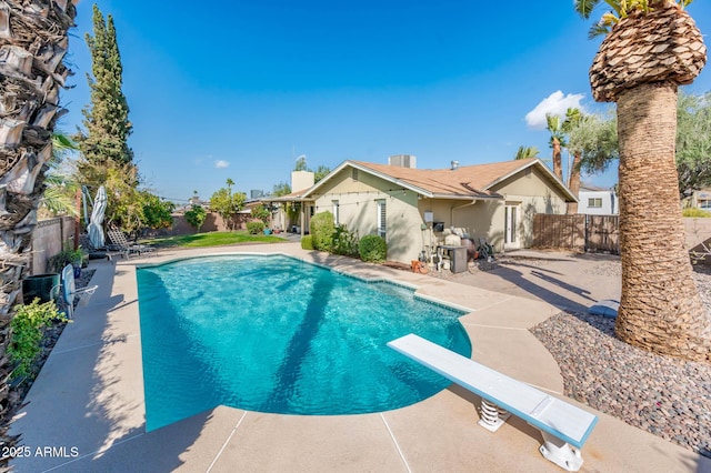 view of pool with a fenced backyard, a diving board, a fenced in pool, and a patio