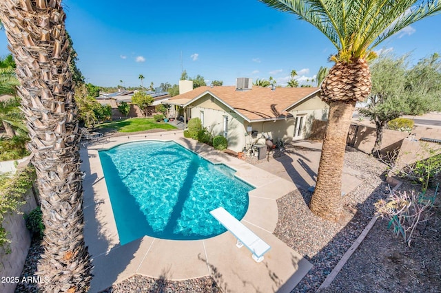 view of swimming pool with a fenced backyard, a diving board, a fenced in pool, and a patio