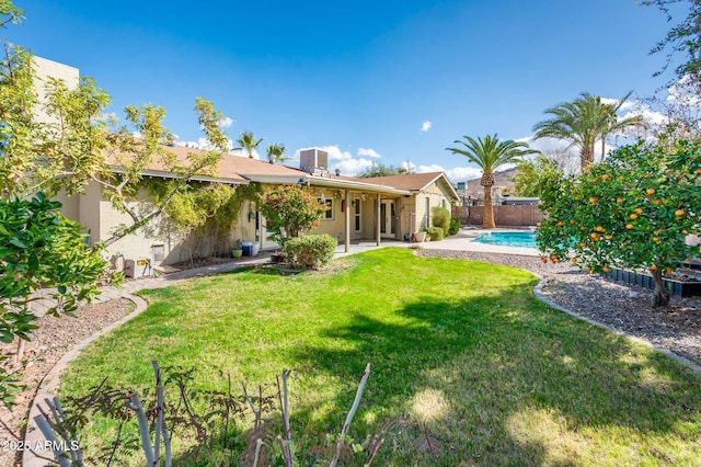 back of house with a fenced backyard, a lawn, a fenced in pool, stucco siding, and a patio area