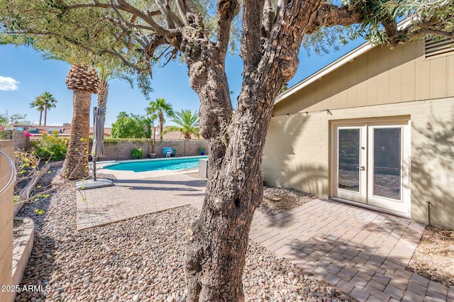 view of pool with a fenced in pool, french doors, a patio area, and a fenced backyard