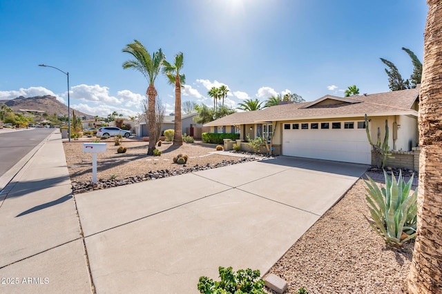 ranch-style house with driveway, an attached garage, and stucco siding