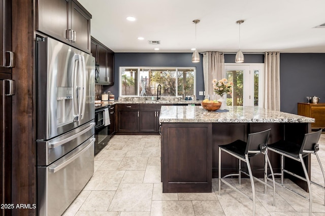 kitchen with dark brown cabinetry, stainless steel fridge, a center island, black range with electric cooktop, and a sink