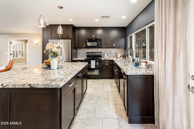 kitchen featuring tasteful backsplash, visible vents, a sink, dark brown cabinets, and black appliances