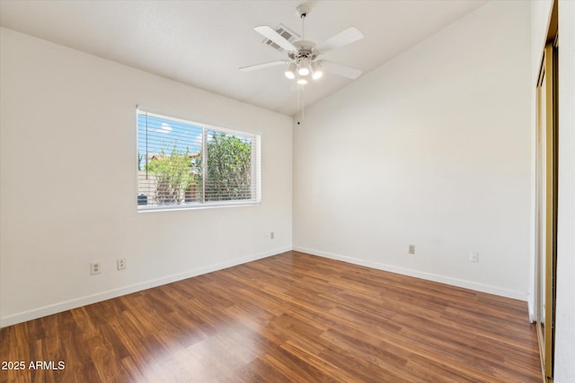 empty room with wood finished floors, visible vents, vaulted ceiling, a ceiling fan, and baseboards